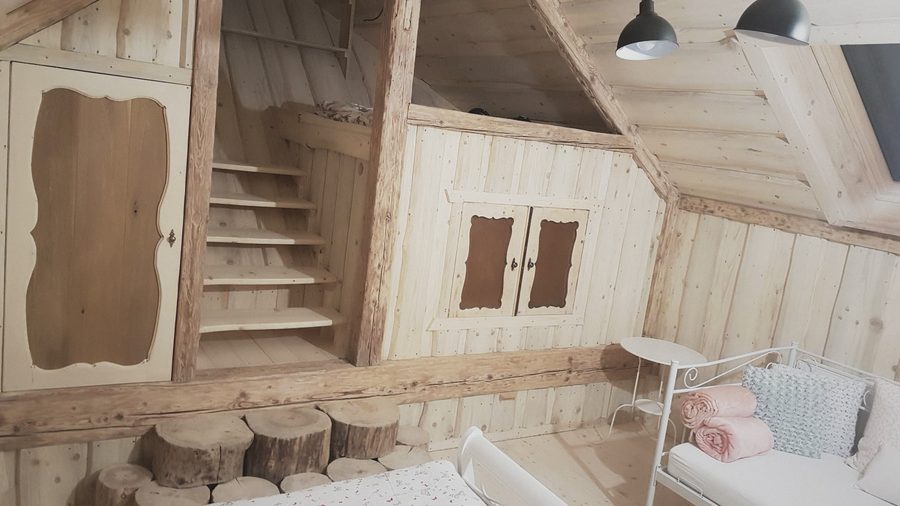 Dřevěná dvířka a schůdky v podkrovní ložnici