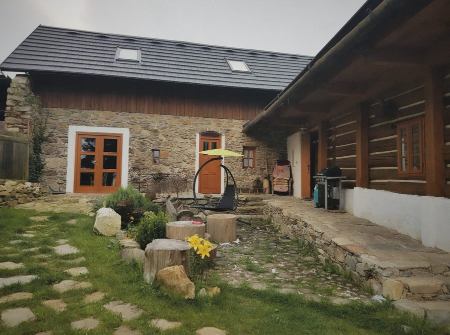 Zahrada s kamennými nášlapy, houpací křeslo a kamenný domek